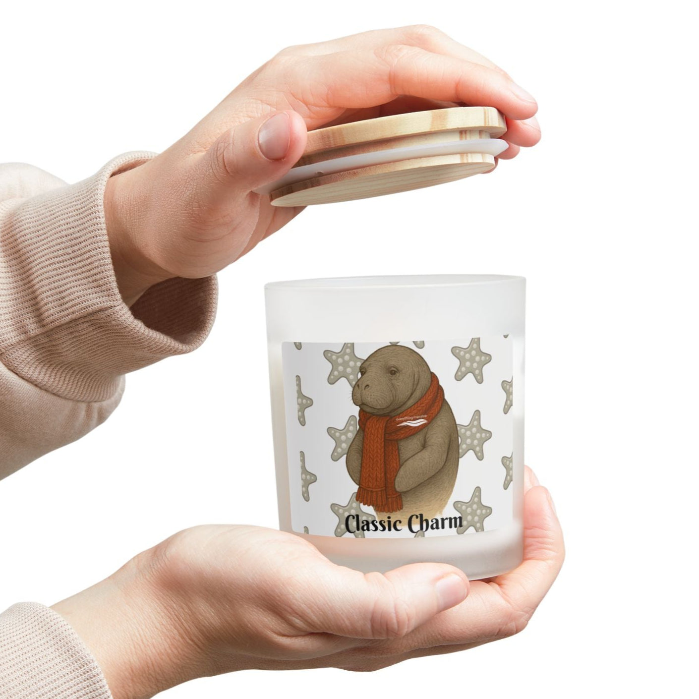 Person holding a small glass jar with a bear design and 'Classic Charm' text on a white background