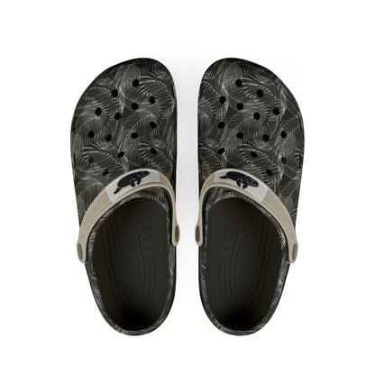 A pair of black and gray palm-leaf patterned clogs with beige straps and a black beaver logo, shown from a top-down view on a white background.