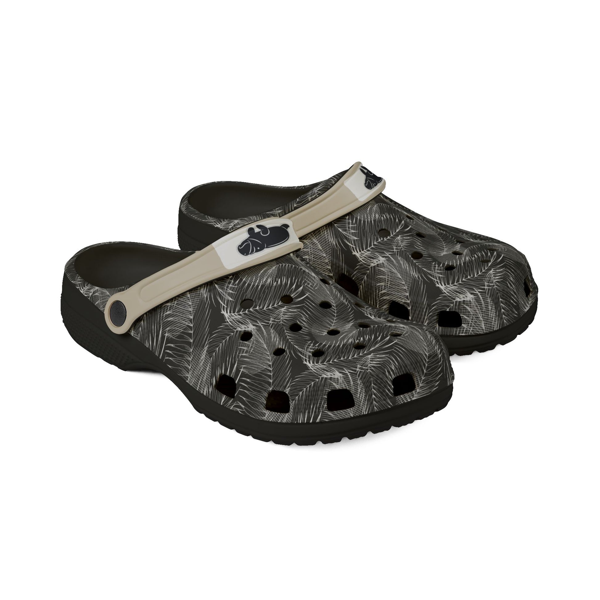 A pair of Croc-style clogs with a black and gray palm leaf pattern, featuring a beige strap with a black logo.