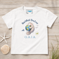 A white short-sleeve t-shirt with a custom graphic print of a manatee hugging a globe and the text 'Hug What You Love GAIA'. The shirt is displayed flat on a light wood background with decorative seashells and grass.