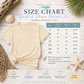 A size chart graphic for the Drift & Dream Manatee Tee by everything manatee, showing a cream-colored t-shirt and a size table with measurements for S through 4XL. The image is styled with a flat-lay of a matching t-shirt, seashells, a starfish, and tropical leaves on a whitewashed wood background.