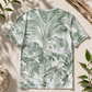 T-shirt with tropical leaf pattern on a beige surface with leaves and branches.