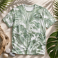Tropical leaf patterned shirt on a natural background with leaves and stones.