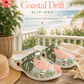 Pair of floral slip-ons on a wooden surface with a coastal background