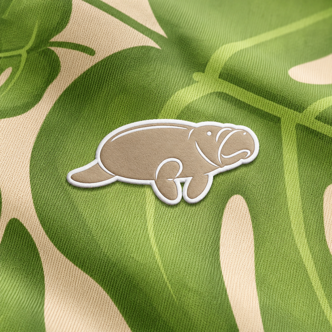 Patch of a platypus on a fabric with green and beige leaf pattern