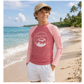 Child wearing a pink long-sleeve shirt with a logo on a beach