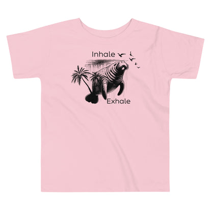 A pink toddler t-shirt with a graphic of a manatee and the text 'Inhale' and 'Exhale' on it.