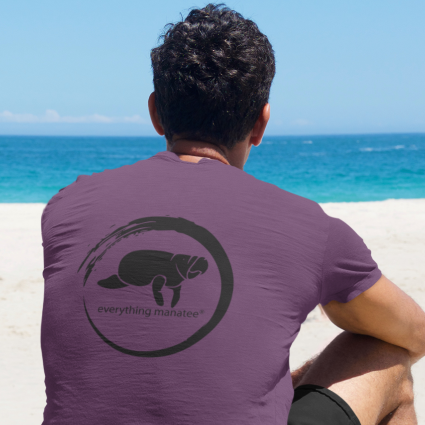 Lifestyle shot of a man wearing Midnight Grape Manatee Wave T-Shirt from the back, showing relaxed fit and unique wave design.