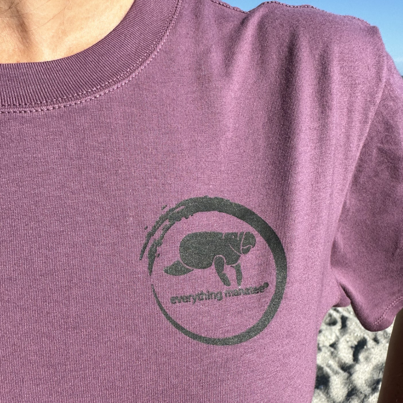 Zoomed-in shot of the front logo on Midnight Grape Manatee Wave T-Shirt, featuring a playful manatee and lettering.