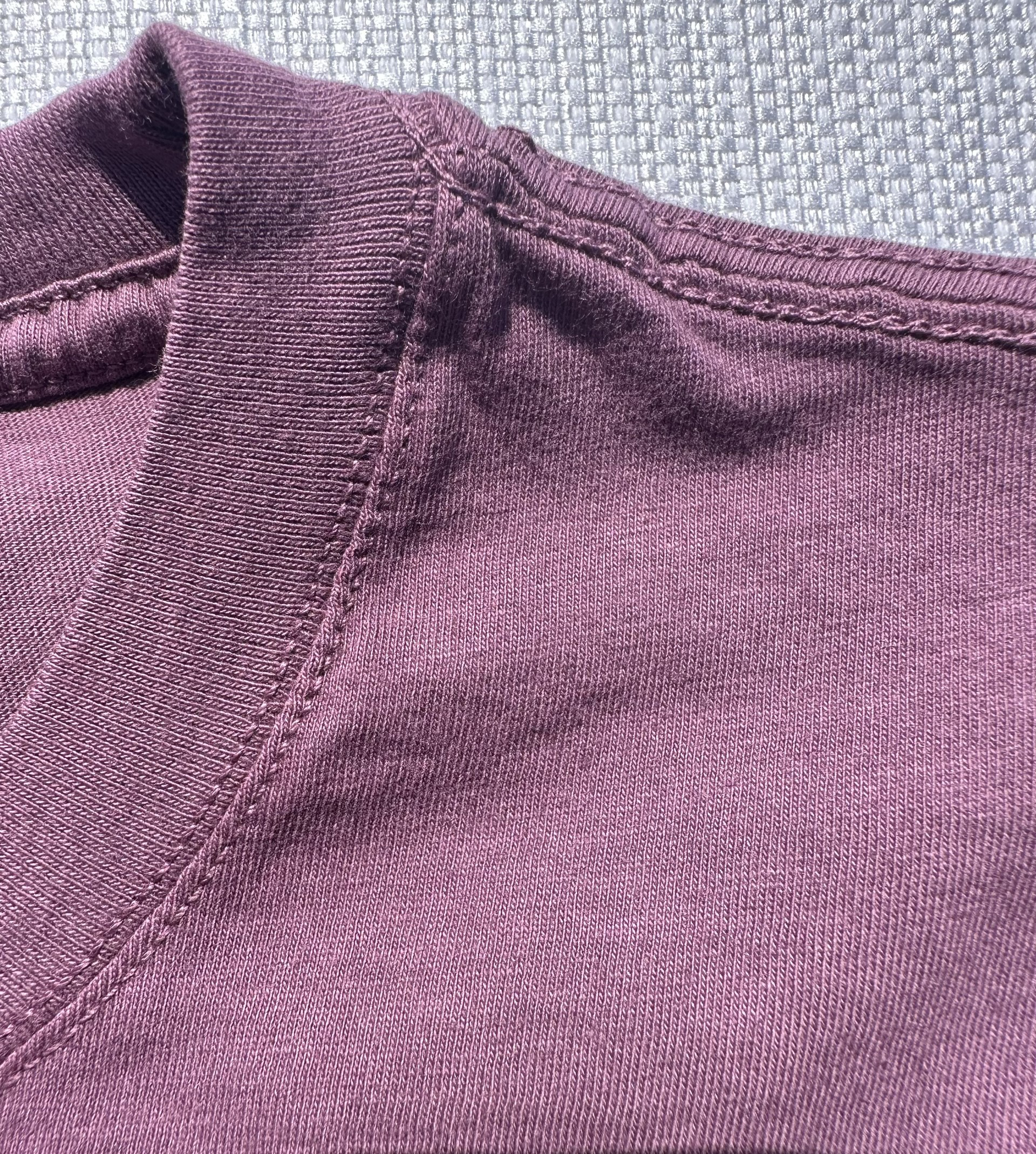 Zoomed-in shot of the neck and shoulder seams on Midnight Grape Manatee Wave T-Shirt, featuring sturdy stitching and a comfortable fit.
