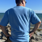 Lifestyle shot of back view of Ocean Blue Manatee Wave Pocket T-Shirt